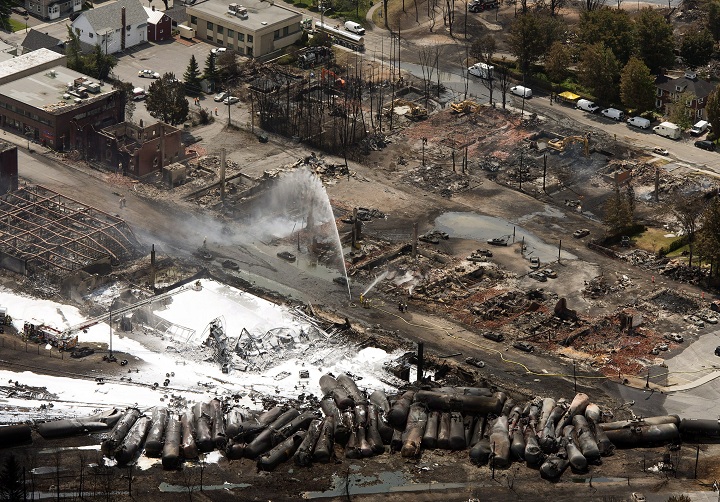 The downtown core lays in ruins as fire fighters continue to water smoldering rubble Sunday, July 7, 2013 in Lac-Mégantic, Quebec after a train derailed ignited tanker cars carrying crude oil.  (CP/Ryan Remiorz) .