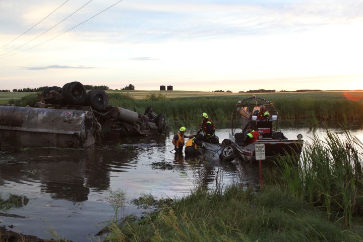 Crews work to recover a car and semi truck from a slough near Lloydminster, Saskatchewan Saturday, July 27, 2013.
