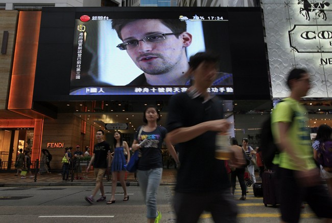 This June 23, 2013 file photo shows a TV screen with a news report on Edward Snowden at a shopping mall in Hong Kong.