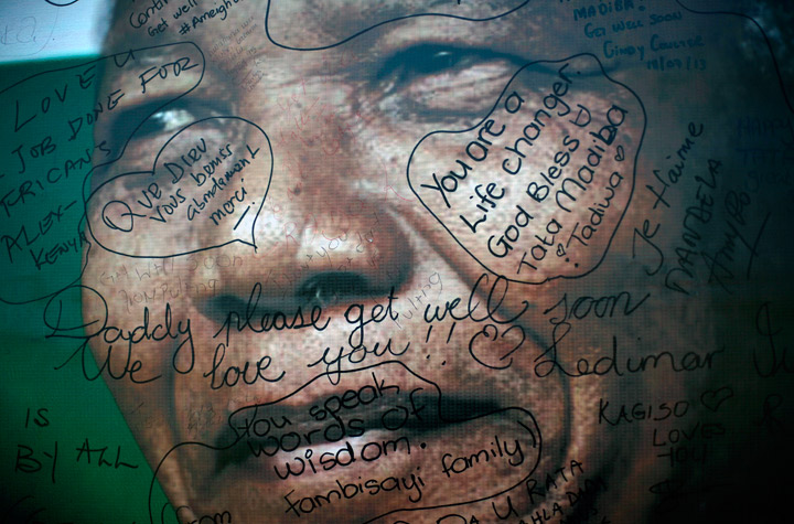 Messages left by supporters are seen on poster depicting former South African President Nelson Mandela set outside his Soweto home, outside of Johannesburg, South Africa, Thursday July 18, 2013. 
