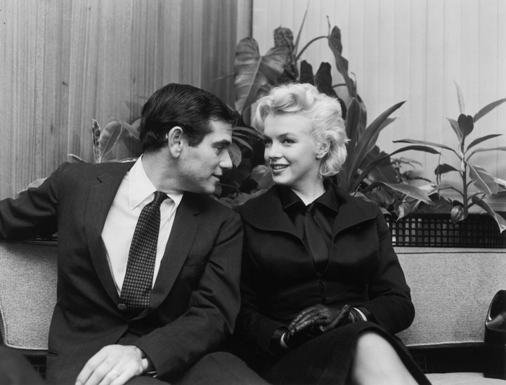 25th February 1956: Actor Marilyn Monroe (1926 - 1962) and photographer Milt Greene sitting and talking after their arrival from New York at LA Airport, Los Angeles, California. 
