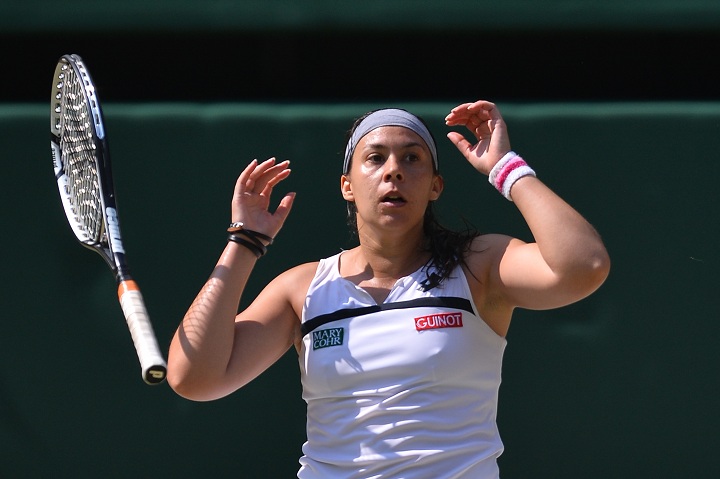 France's Marion Bartoli drops her racquet and falls to her knees as she beats Germany's Sabine Lisicki in their women's singles final match on day twelve of the 2013 Wimbledon Championships tennis tournament at the All England Club in Wimbledon, southwest London, on July 6, 2013. 