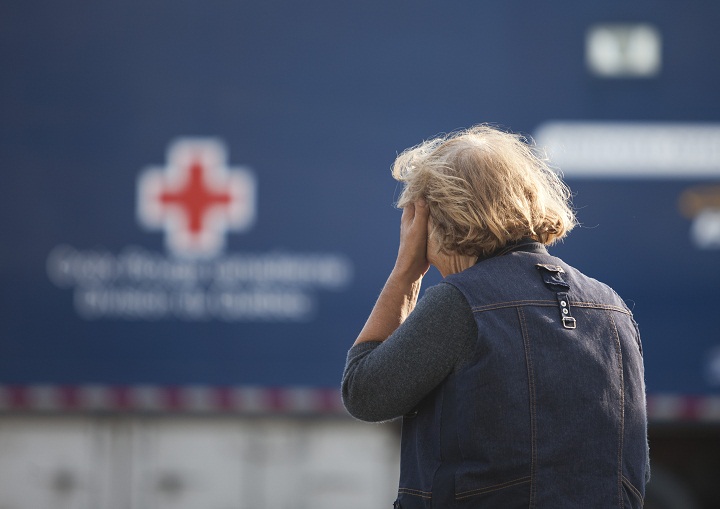 A concerned resident waits July 7, 2013 near an aid station set up after a freight train loaded with oil derailed in Lac-Megantic in Canada's Quebec province, sparking explosions that engulfed about 30 buildings in a wall of fire. 
