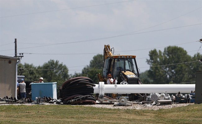 Workers move equipment in the yard at the Enbridge Key Terminal near Salisbury, Mo., Tuesday, July 16, 2013. 
