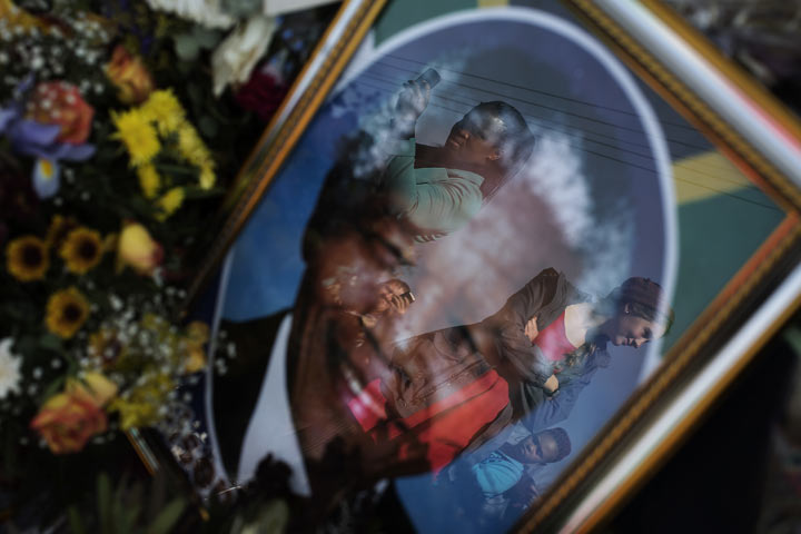 Well wishers are reflected in a portrait of former South African President Nelson Mandela outside the Medi Clinic Heart Hospital in Pretoria, where Mandela lays in critical condition on July 7, 2013. 
