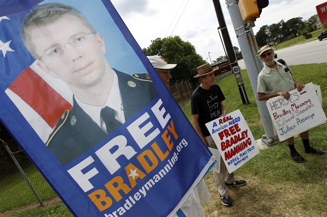 In this July 30, 2013 file photo, supporters of Army Pfc. Bradley Manning protest outside of the gates at Fort Meade, Md. Manning was acquitted of aiding the enemy, the most serious charge he faced, but was convicted of espionage, theft and other charges, more than three years after he spilled secrets to WikiLeaks.