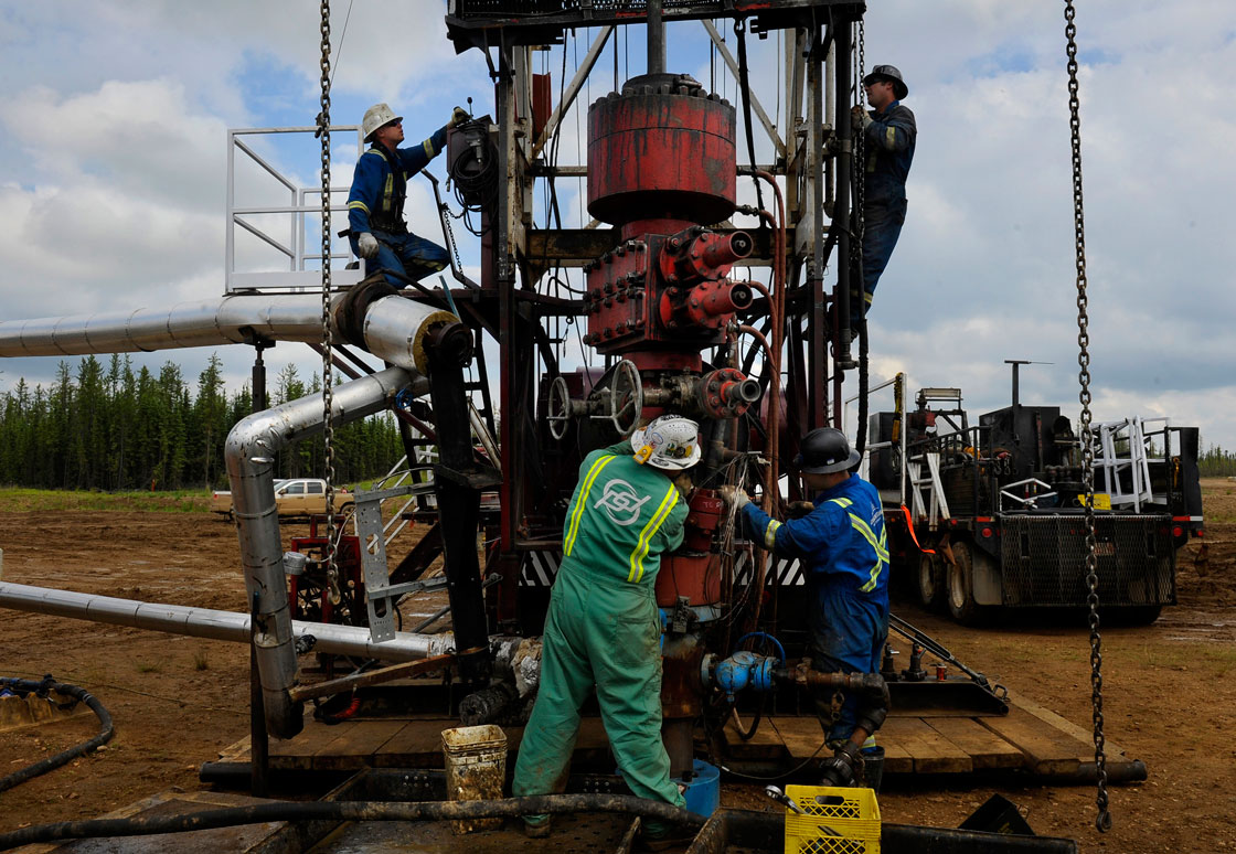 Oil rig workers tend to a pump in near Fort McMurray, Alberta. 