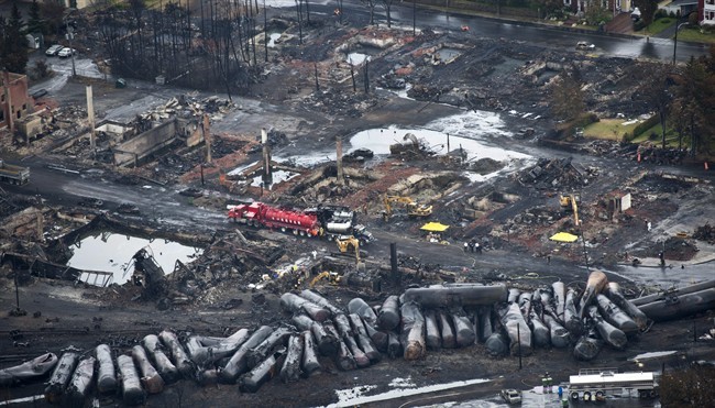 Workers comb through debris Tuesday, July 9, 2013, after a train derailed Saturday causing explosions of railway cars carrying crude oil in Lac-Megantic, Quebec.
