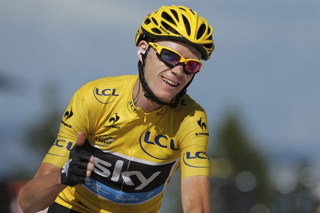 Christopher Froome of Britain, wearing the overall leader's yellow jersey, flashes a thumbs up and a big smile as crosses the finish of the 20th stage of the Tour de France cycling race.