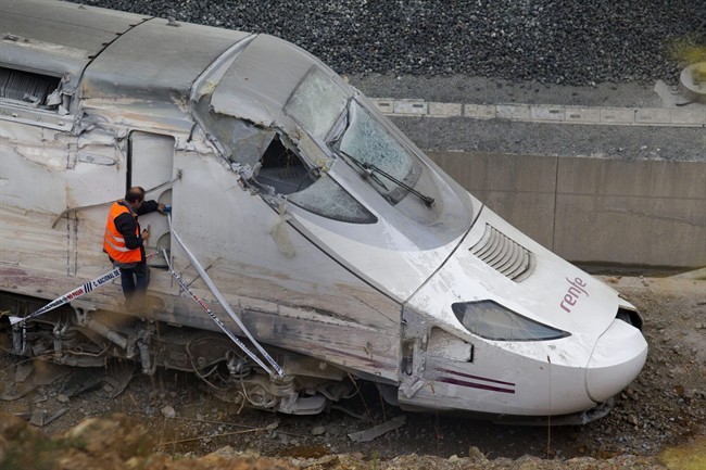 FILE - In this July 25, 2013 file photo, a rail personnel worker checks the cabin of a derailed train following an accident in Santiago de Compostela, Spain.