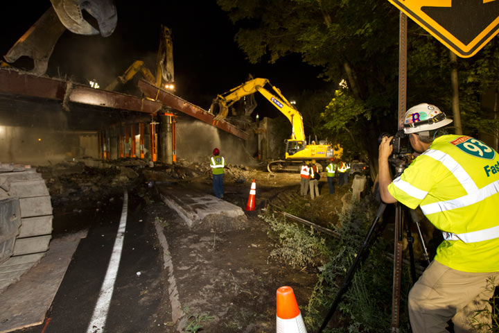 Stephen SeteDucatti sets up a camera that will take a picture every 15 seconds, as the demolition crew tears down the Valley Street Bridge southbound section of I-93 on Friday, July 22, 2011. 