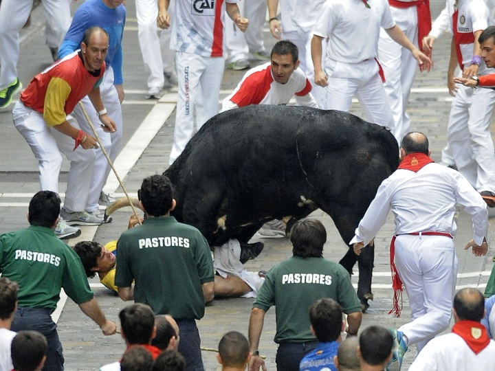 A participant is gored by a El Pilar's bull during the sixth bull run of the San Fermin Festival in Pamplona, northern Spain on July 12, 2013.