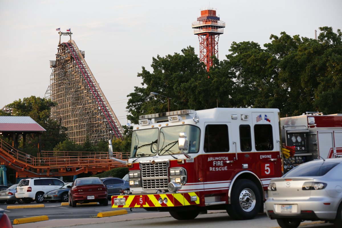 Emergency personnel are on the scene at Six Flags Over Texas in Arlington, Texas, after a woman died on the Texas Giant roller coaster, background left, on Friday, July 19, 2013.