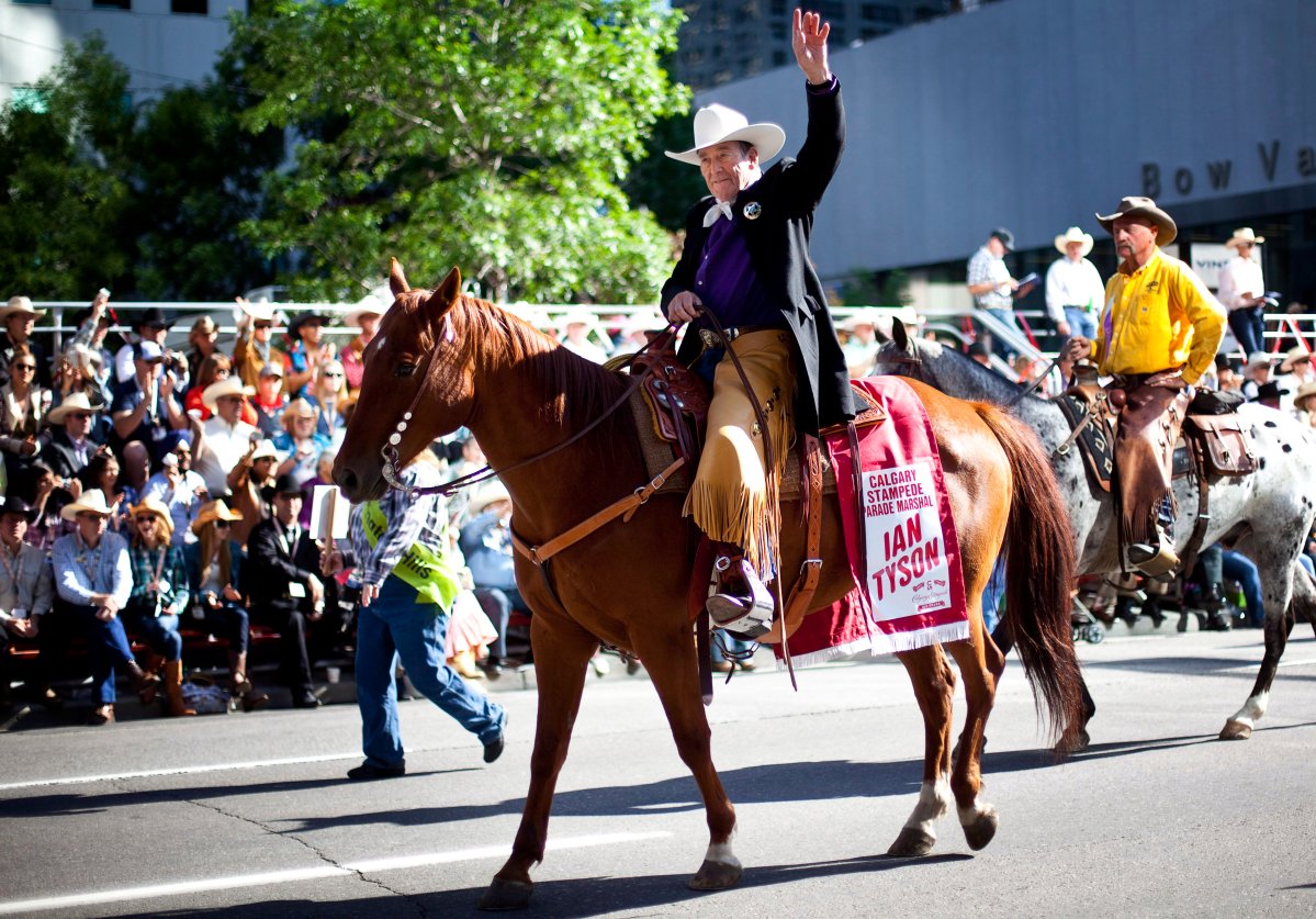 Country music legend and parade marshal Ian Tyson waves to the crowd during the Calgary Stampede parade in Calgary, Friday, July 6, 2012. The parade featured 700 horses, 26 marching bands and 12 street sweeping trucks to clean horse droppings.