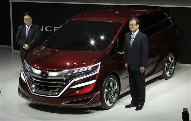 FILE - In this April 20, 2013 file photo, Honda Motor Co. President and Chief Executive Takanobu Ito, right, and Seiji Kuraishi, president of Honda Motor (China), pose for photographers with the company's new Concept M at the Shanghai International Automobile Industry Exhibition.