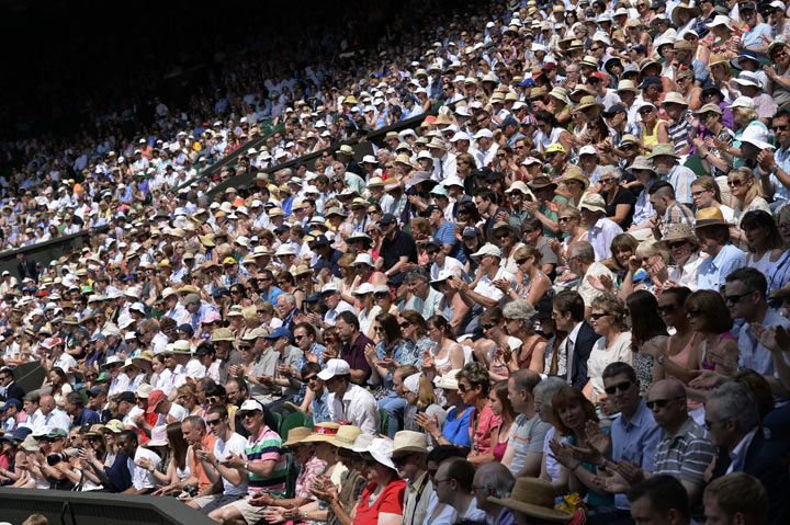 Spectators applaud in the crowd as Argentina's Juan Martin Del Potro plays Serbia's Novak Djokovic in the first men's singles semi-final match on day eleven of the 2013 Wimbledon Championships tennis tournament at the All England Club in Wimbledon, southwest London, on July 5, 2013. 