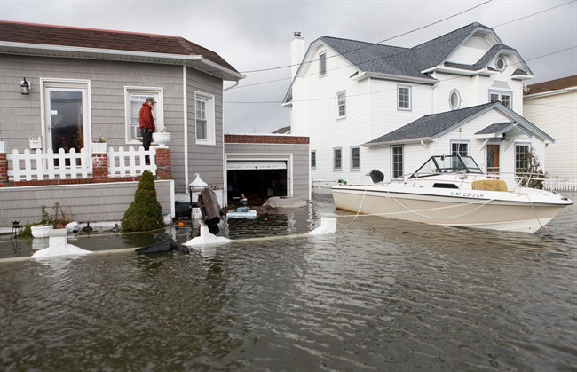 This Oct. 30, 2012 file photo shows a boat floating in the driveway of a home on Long Island in the flooding aftermath of Superstorm Sandy, in Lindenhurst, N.Y. 
