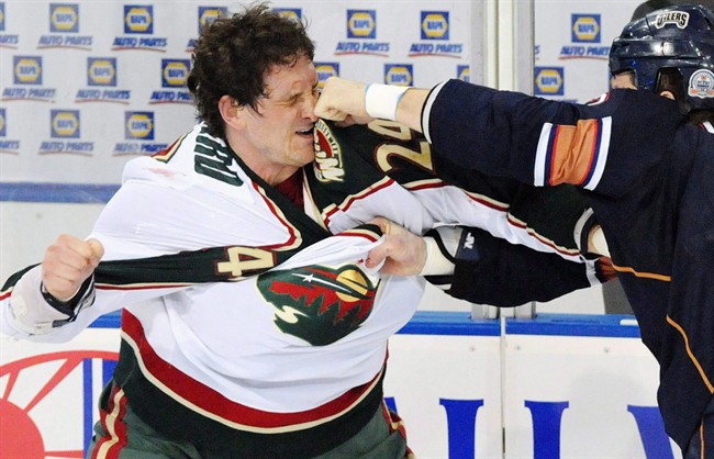 Minnesota Wild left wing Derek Boogaard (24) gets hit by Edmonton Oilers left wing Steve MacIntyre (33) in a fight during first period NHL hockey action in Edmonton on Jan. 30, 2009. A number of pro football and hockey players, who had suffered repeated concussions have had symptoms suggestive of chronic traumatic encephalopathy, or CTE. THE CANADIAN PRESS/Jimmy Jeong, File.