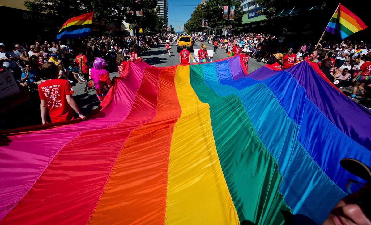 A rainbow flag is held by marchers in the annual Pride parade in Vancouver's West End.