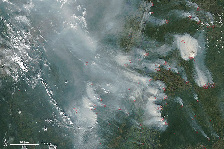 Smoke and wildfires in the Khanty-Mansiyskiy and Yamal-Nenetskiy districts in Siberia.  The areas in red are abnormally warm surface temperatures.