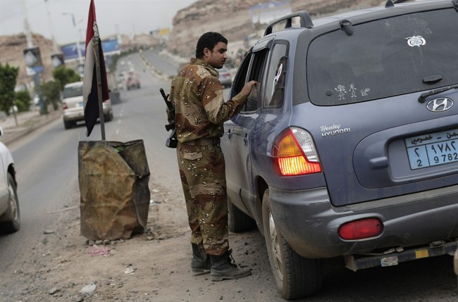 A Yemeni soldier inspects a car at a checkpoint on a street leading to the U.S. embassy in Sanaa, Yemen, Sunday, Aug. 4, 2013.