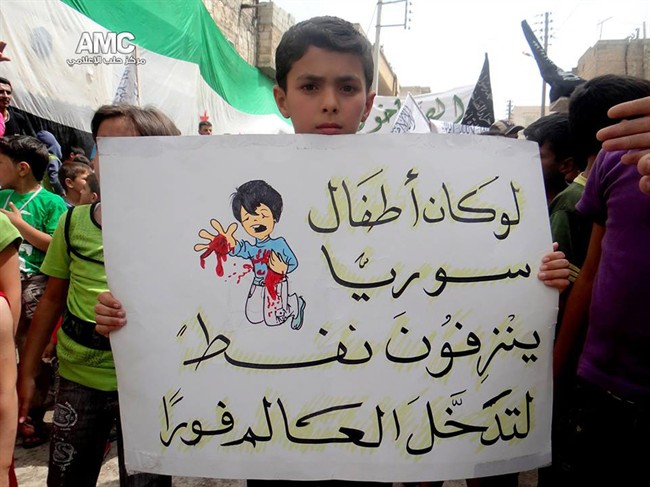 Citizen journalism image provided by Aleppo Media Center AMC which has been authenticated based on its contents and other AP reporting, shows a Syrian boy holding an Arabic placard that reads: "if Syria's children bled petrol, the entire world would have intervened," during a demonstration against the alleged chemical weapons attack at the suburbs of Damascus, in Aleppo, Syria, Wednesday, Aug. 21, 2013. THE CANADIAN PRESS/AP, Aleppo Media Center, AMC.