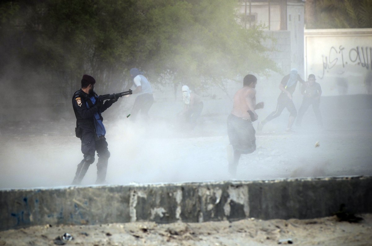 A Bahraini riot policeman ( L ) fires bird shot toward anti-government protestors during demonstration against the ruling regime in the village of Shakhora, west of Manama, on August 14, 2013. Bahraini police headed off a protest against Gulf kingdom's Sunni rulers that the Shiite-led opposition activists called for near the US embassy in defiance of a ban. The police deployment prevented protesters from reaching the spot designated by the Bahrain Rebellion Movement, Tamarod, for the main rally outside the US embassy in the capital Manama.