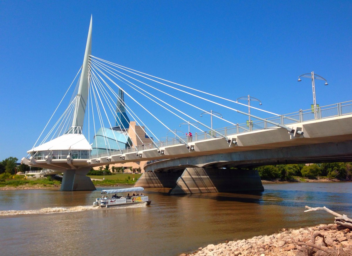 A tour boat moves down the Red River in Winnipeg on August 11, 2013, under the Provencher Bridge, past the Canadian Museum for Human Rights at the Forks.