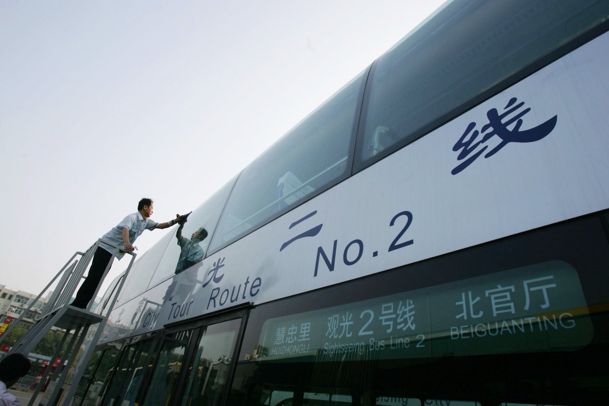 File -- A driver cleans a bus at a bus station on July 20, 2008 in Beijing, China.