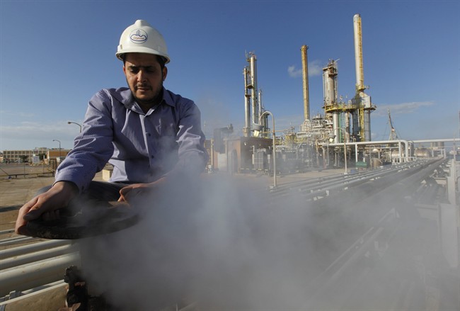 FILE - In this Feb. 26, 2011 file photo, a Libyan oil worker at a refinery inside the Brega oil complex, in Brega, eastern Libya. 