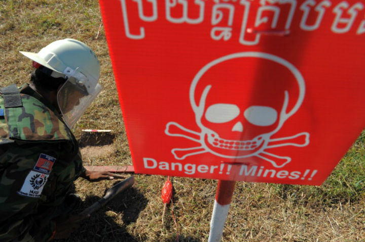 A Cambodian deminer from the Cambodia Self Help Demining (CSHD) probes for mines after being detected with metal detectors in the field at the Training and Mine Unexploded Ordnance Clearance Center (TMCC) in Oudong, some 40 kilometers north of Phnom Penh on November 27, 2011.