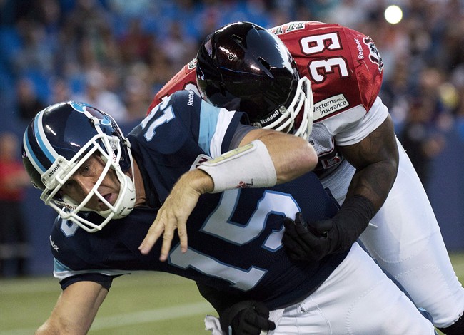 Toronto Argonauts quarterback Ricky Ray, left, is injured on a tackle by Calgary Stampeders defensive linemen Charleston Hughes, right, during first half CFL football action in Toronto on August 23, 2013.