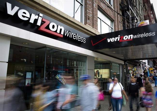 Pedestrians pass a Verizon Wireless store on Canal Street, June 6, 2013, in New York. 