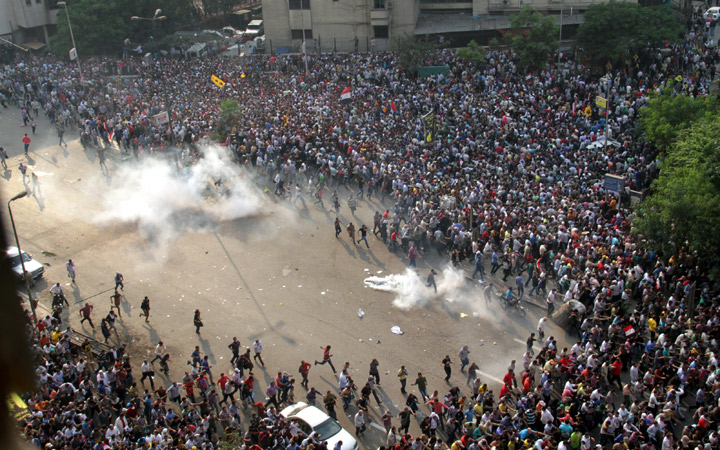 Egyptian Muslim brotherhood and supporters of ousted president Mohamed Morsi run for cover from tear gas during clashes with riot police along Ramsis street in downtown Cairo, on October 6, 2013. (Photo credit: Getty Images)