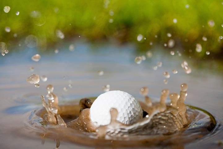 Golf ball splashing into water.