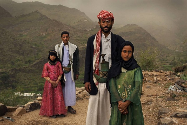 Tahani, 8, is seen with her husband Majed, 27, and her former classmate Ghada, 8, and her husband outside their home in Hajjah, Yemen, July 26, 2010.