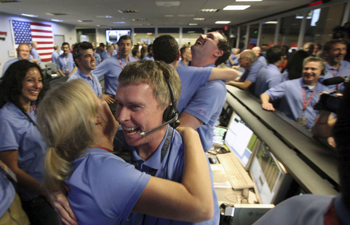 Peter Ilott (foreground) hugs his co-worker after the team at the Jet Propulsion Laboratory in Pasadena, Calif., received news that Curiosity had landed successfully on Mars.