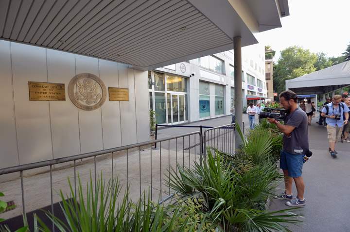 journalist films the main entrance of the US consulate in Milan, after a bomb alert on August 6, 2013, that forced the evacuation of the building.