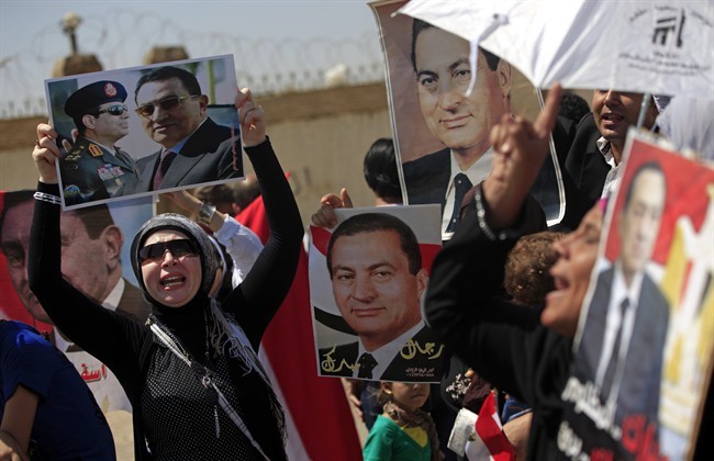 Supporters of former Egyptian President Hosni Mubarak, hold posters of him as they protest outside the Cairo Police Academy--turned--court, Cairo, Egypt, Sunday, Aug. 25, 2013.