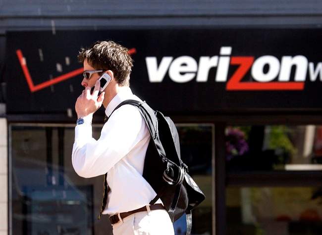 FILE - A Monday, July 28, 2008 photo from files showing Eric Roden speaking on his cell phone as he walks past a Verizon store in Portland, Ore.