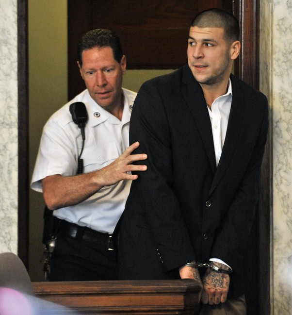 Former New England Patriot football player Aaron Hernandez, is lead into court in Attleboro, Mass., Thursday, Aug. 22, 2013. 