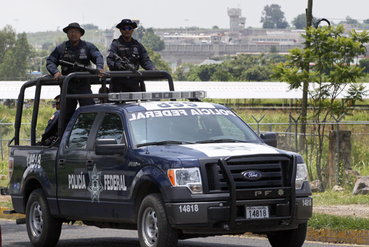 A unit of the Mexican Federal Police patrols the surroundings of the Puente Grande State prison (background) in Zapotlanejo, Jalisco State, Mexico, on 9 August, 2013 where former top Mexican cartel boss Rafael Caro Quintero -- who masterminded the kidnap and murder of a US anti-drug agent in 1985 -- was informed early Friday that a court ordered his release. 