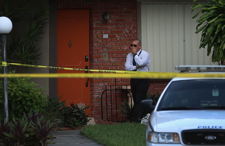 A police detective stands near the front door to a townhouse where seemingly a husband reportedly confessed on Facebook to murdering his wife on August 8, 2013 in Miami, Florida. 