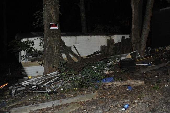 A Pennsylvania State Police Trooper guards the dilapidated home of alleged shooter 59-year-old Rockne Newell, Tuesday, Aug. 6, 2013 in Saylorsburg, Pa. Police said Newell entered the Ross Township Municipal Building Monday evening and shot several people. 