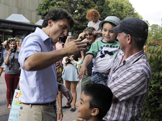 Liberal Leader Justin Trudeau reacts to a high-five while meeting supporters in Charlottetown, P.E.I. on Tuesday, Aug. 27, 2013. 