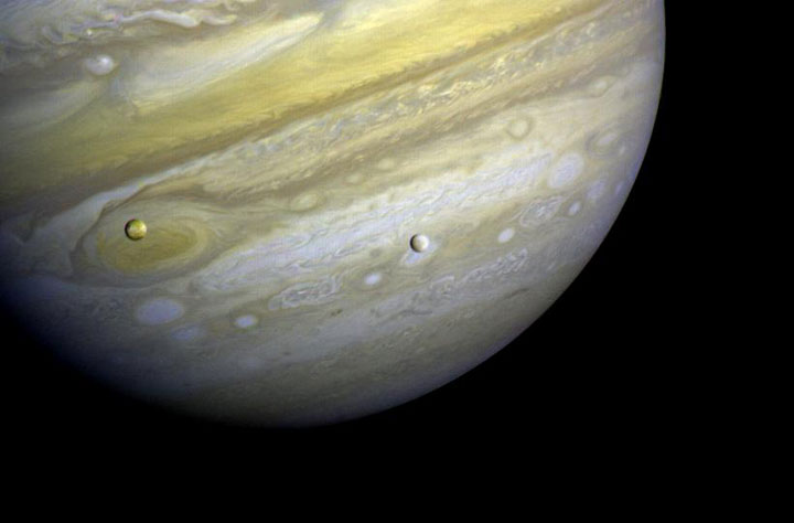Jupiter and two of its moons, Io, (left) and Europa (right).