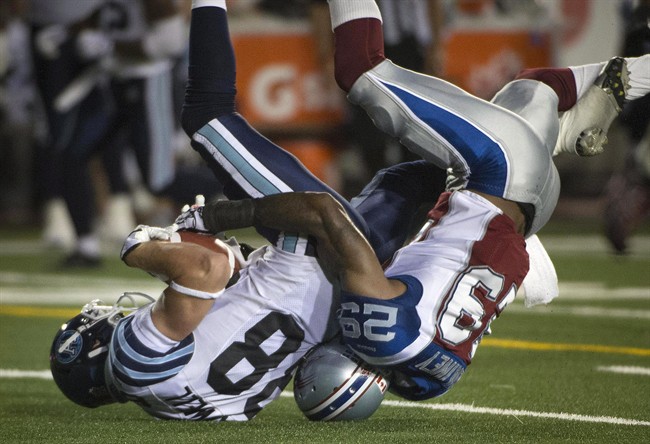 Montreal Alouettes' Ed Gainey takes Toronto Argonauts' Mike Bradwell,for a roll and tackle during first half CFL action against the Montreal Alouettes in Montreal, Thursday Aug. 8, 2013. 