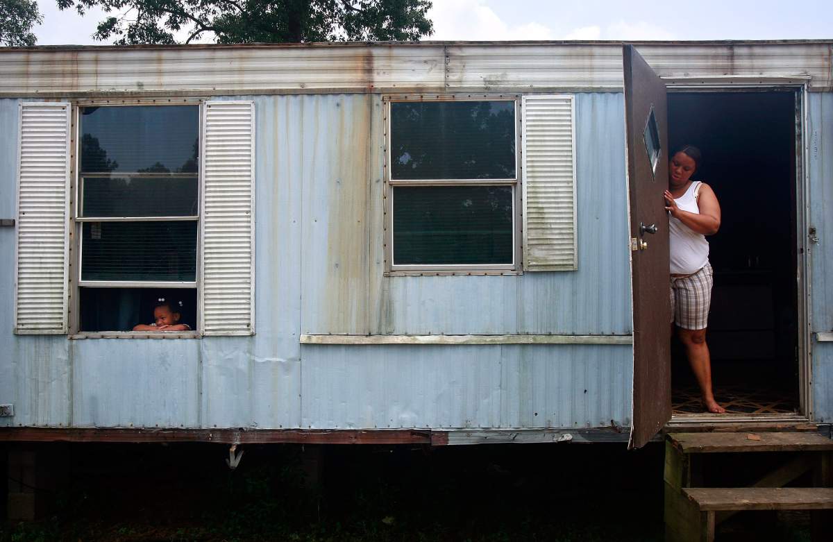 FLUKER, LA - MAY 5: Christy Sibley (R) and daughter Rosheka stand in their trailer May 5, 2009 in Fluker, Louisiana. The highly impoverished rural town has very few jobs and no mayor. The recession has hit many Americans hard, but the rural Lower Mississippi Delta region has had some of the nation's worst poverty for decades. The mechanization of agriculture and movement of textile plants out of the country has left the region's economy in tatters, leaving generational poverty in its wake. 
