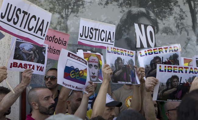 Gay rights protesters hold up posters during a protest in front of the Russian embassy in Madrid, Spain Friday Aug. 23, 2013 against Russia's new law on gays. Protesters, called for the Winter 2014 Olympic Games to be taken away from Sochi, Russia, because of a new Russian law that bans "propaganda of nontraditional sexual relations" and imposes fines on those holding gay pride rallies. Posters read ' Justice, Freedom, That's enough, Boycott Russia and Stop Homophobia'.