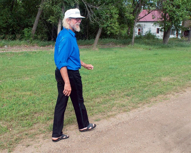In this Aug. 26, 2013, photo Craig Cobb walks along Main Street toward his home in Leith, N.D.